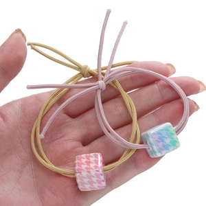 Primo piano di elastici per capelli a doppio filo con cubi in resina pied de poule