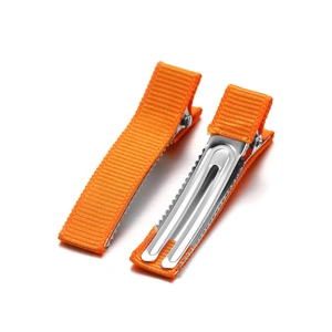 Close-up of orange grosgrain ribbon covered metal alligator hair clips for DIY crafts