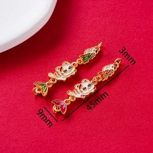 Detailed macro view of vintage enamel cat and fish tail pendants with size measurements