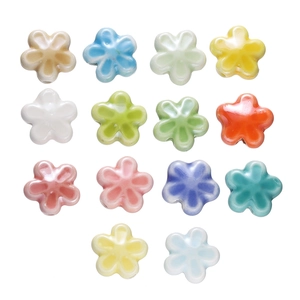Macro-opname van 14 kleurrijke keramische bloemkralen voor het maken van sieraden