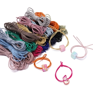 Dettaglio di corde elastiche in nylon colorato da 3mm con ciondoli pied-de-poule e pupazzo