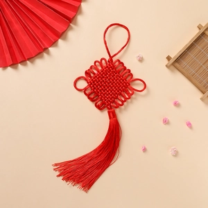 Detailed view of red Chinese knot with tassel, handmade weaving for festive decoration
