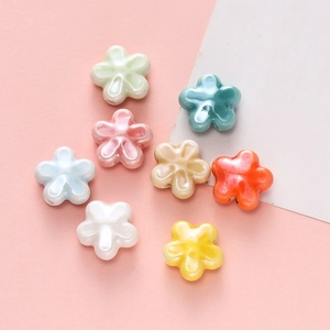 Detail van kleurrijke keramische bloemkralen met vijf bladeren voor DIY sieraden en hobby's