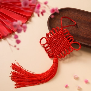 Macro shot of traditional red Chinese knot with long tassels and elegant weave detail