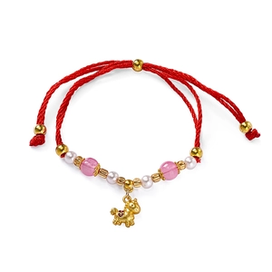 Macro view of braided red rope bracelet with golden zodiac horse charm and beads