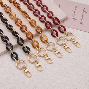 Detail of acrylic purse chains in amber and black with gold spring ring clasps