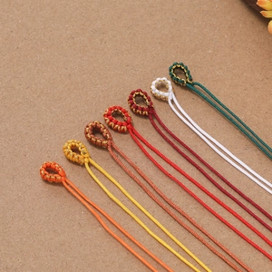 Detail von bunten geflochtenen Kordelverbindern mit Goldseidenfaden für DIY Schmuck