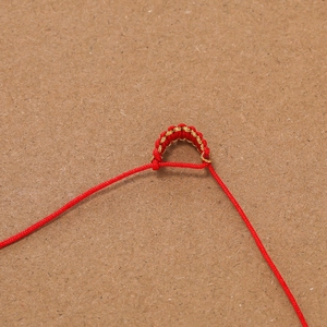 Detailansicht der rot-goldenen geflochtenen Seilschlaufen für handgefertigten Schmuck