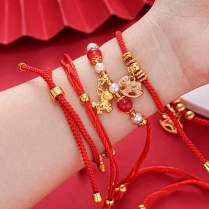 Red braided New Year bracelet with gold horse charms and pearls for luck and fortune