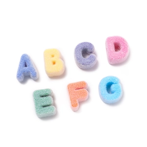 Macro detail of colorful velvet-flocked acrylic letter beads with soft fuzzy texture for DIY crafts