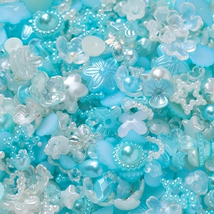 Détail macro de perles DIY bleues et blanches en formes de fleurs, étoiles et perles