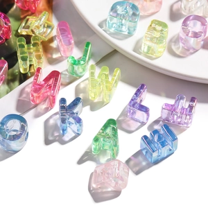 Detailed view of translucent iridescent acrylic letter beads with holes for DIY jewelry