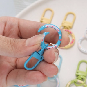 Detail of blue donut spring ring clasp with white polka dots and rotating swivel base
