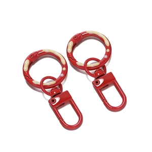 Detail of red lacquered swivel lobster clasps with cream drip-glaze decorative rings