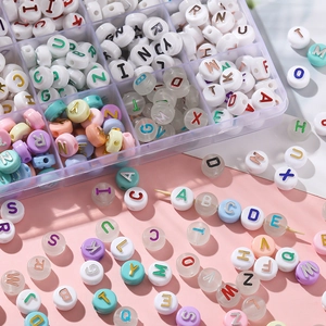 Macro shot of 6x10mm acrylic letter beads with gold stamping for DIY jewelry making