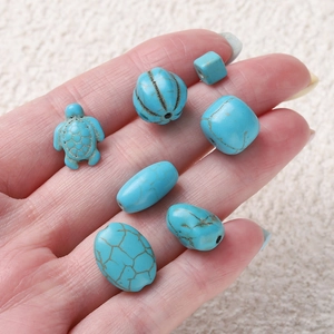 DIY jewelry making beads set featuring turquoise turtle and irregular shapes held in hand