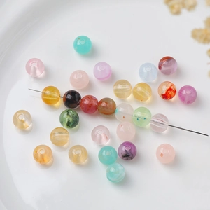 Macro shot of 8mm colorful acrylic beads with marble texture and DIY jewelry needle