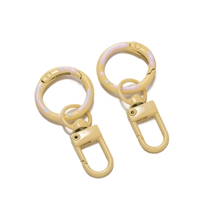 Macro detail of cream yellow painted metal spring ring clasp with colorful polka dots