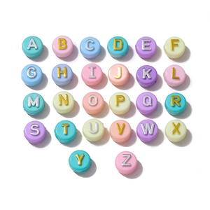 Macro detail of 6x10mm acrylic flat beads with golden letters for DIY jewelry making