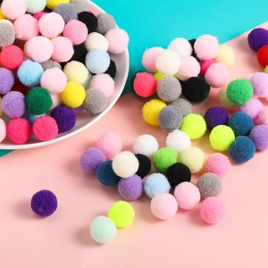 Primer plano de pompones de poliéster de 1,5 cm de colores en un plato para manualidades DIY