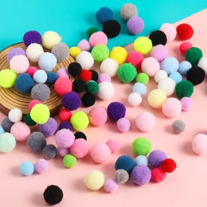 Detalle de pompones de poliéster coloridos en varios tamaños para manualidades DIY
