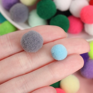 Primer plano macro de pompones de poliéster de 1cm y 1,5cm para manualidades y costura