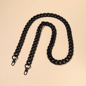 Matte black acrylic bag chain strap with swivel lobster clasps on smooth beige background