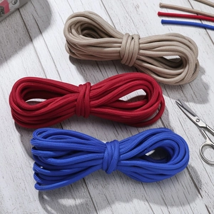 Detail of 5mm colorful braided nylon paracords with scissors on white wooden background