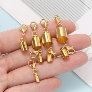 Macro shot of assorted golden lobster clasps and cord end caps in various sizes