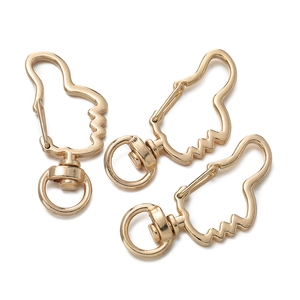 Three gold thumb-up shaped metal lobster clasps with swivel rings on white background