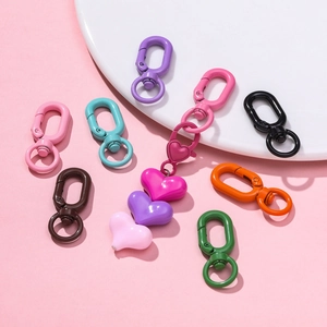 Close-up of colorful lacquered metal lobster clasps and heart charms for DIY accessories