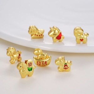 Detalle de cuentas de caballo del zodiaco dorado con esmalte y caracteres de la suerte