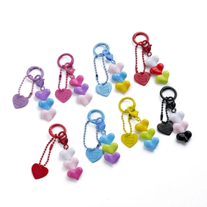 Detail of colorful resin heart charms and metal keychains in various vibrant color options