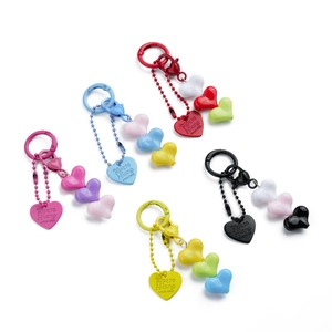 Detailed view of colorful heart-shaped beaded keychains in five vibrant color palettes