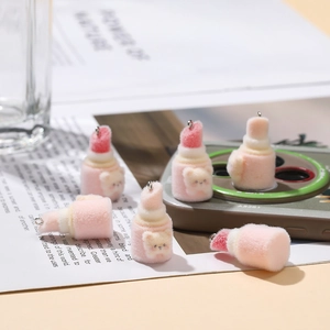 Macro detail of plush lipstick charms with cute bear heads and metal keyrings