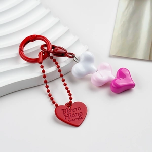 Detail of red heart keychain with colorful resin beads and engraved alloy pendant