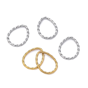 Détail de bagues torsadées en acier inoxydable argent et or sur fond blanc