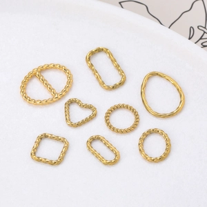 Détail macro de huit cadres de bijoux assortis en métal torsadé doré sur fond blanc