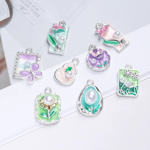 Detail view of pastel enamel alloy charms with butterfly motifs and faux pearls for DIY crafts