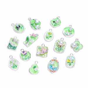 Macro view of 14 green enamel pendants with silver metal frames and faux pearls