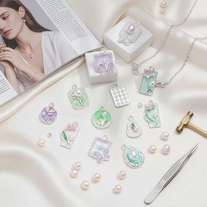 Flat lay of alloy butterfly pendants with faux pearls and jewelry making tools