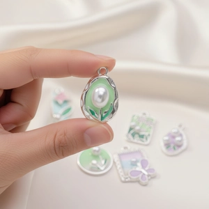 Close-up of DIY heart-shaped butterfly pendant with macaron enamel and white pearl