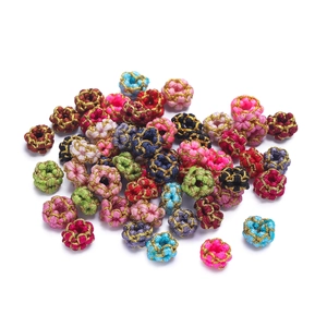 Close-up of handmade DIY colorful silk and gold wire woven peach blossom knot beads