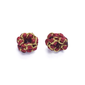 Close-up of handmade red and gold woven silk knot beads for DIY jewelry making