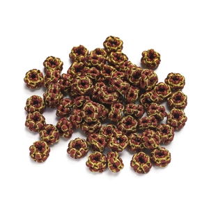 Detailed macro of gold wire wrapped burgundy thread knot beads for DIY jewelry making