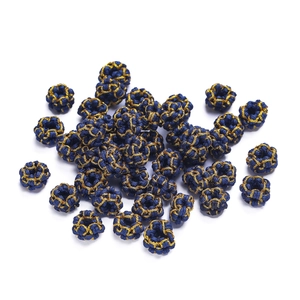 Macro shot of handmade dark blue and gold braided bead accessories for jewelry making