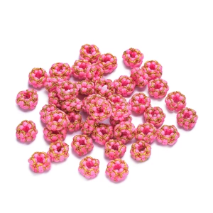 Macro shot of handmade pink and gold wire-wrapped weave beads for DIY jewelry crafting