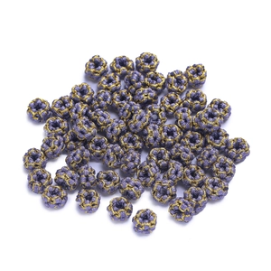 Close-up of handmade purple woven peach knot rings with gold wire for DIY jewelry making