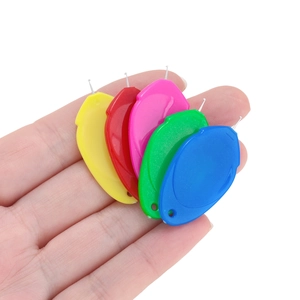 Close-up of five colorful acrylic needle threaders with steel hooks for DIY sewing projects