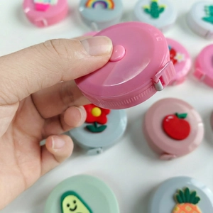 Close-up of portable pink mini tape measure with 3D silicone cactus and floral designs